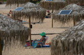Atina plajlarında güneş enerjili telefon sarj şemsiyeleri